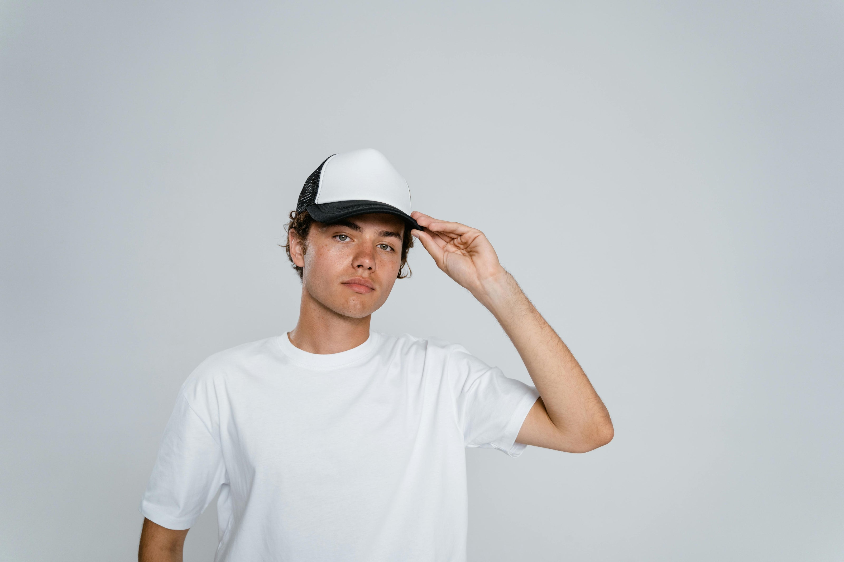 Person wearing a blank trucker cap for custom cap embroidery in Australia